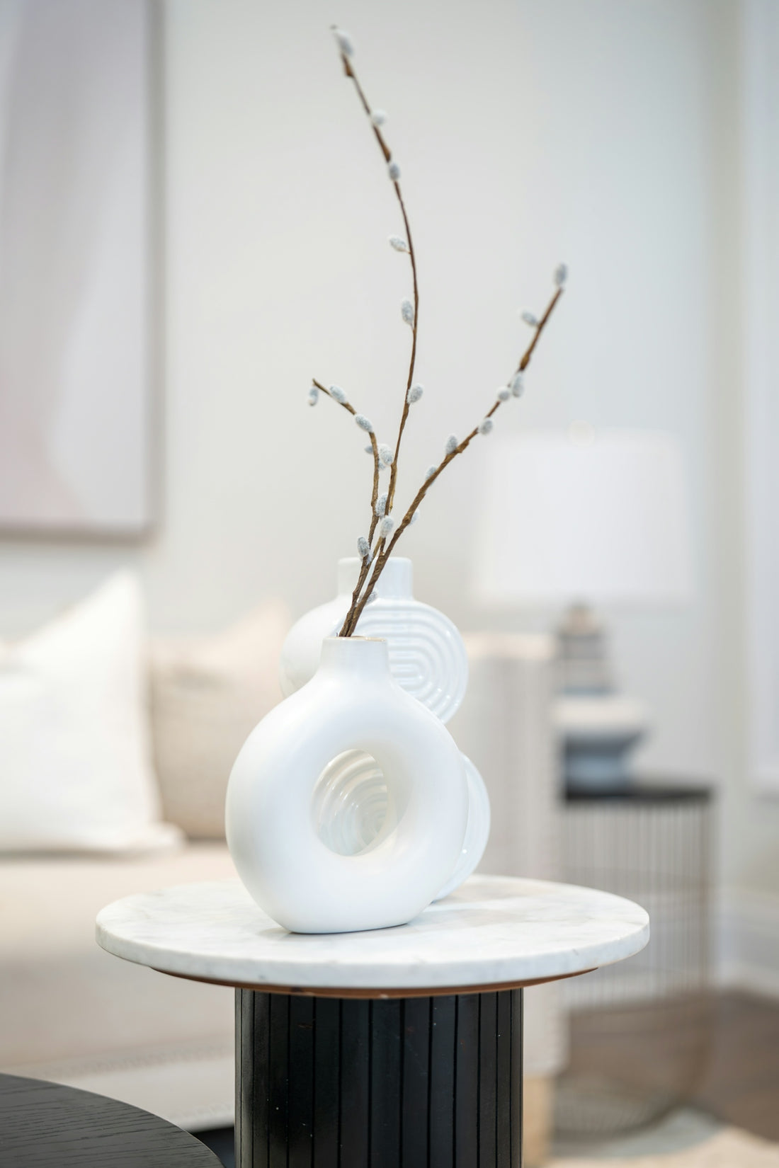 Modern white vase with branches on a marble table
