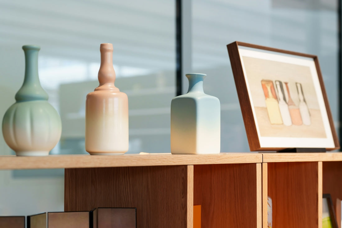Decorative vases and framed art on a light wooden shelf
